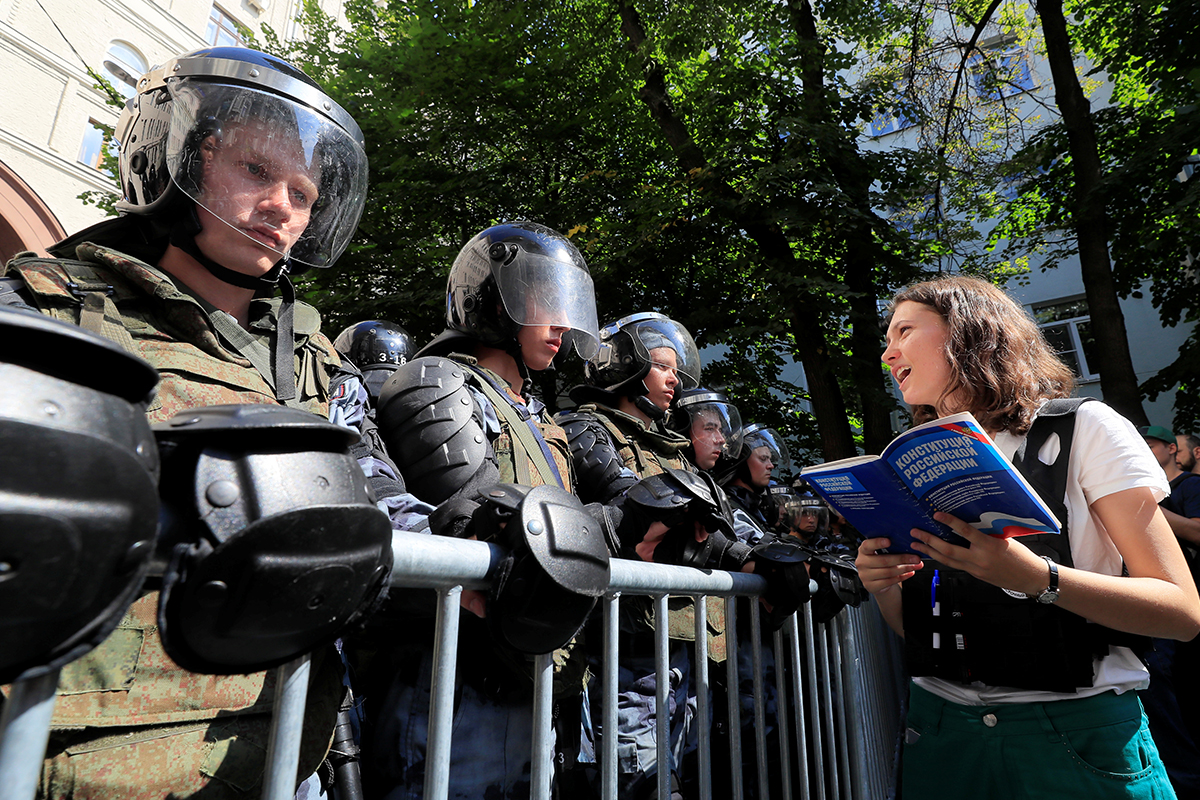 Активистка читает Конституцию РФ сотрудникам правоохранительных органов
