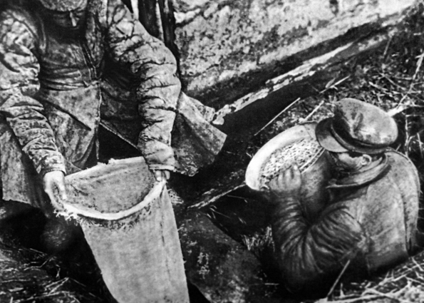 Работники ОГПУ достают из ямы спрятанное зерно, 1932 год