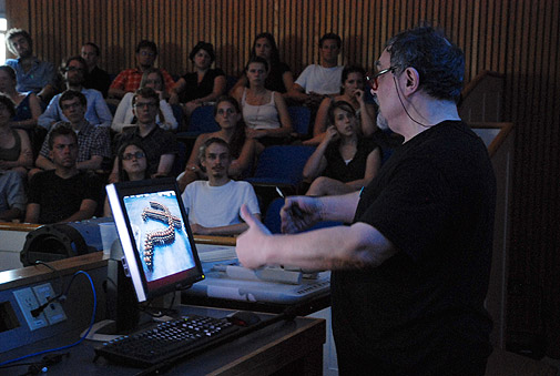 Виталий Комар на лекции показывает предметы из своей коллекции