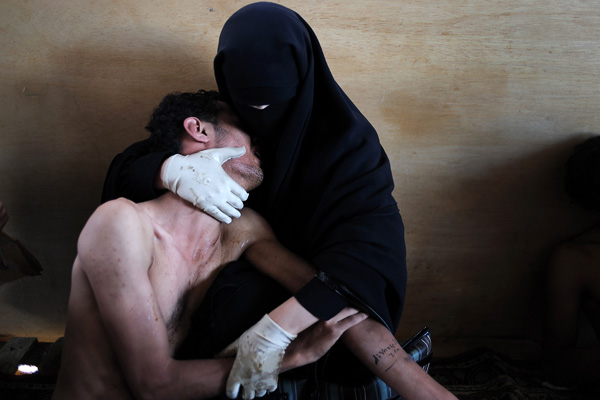 Самуэль Аранда, Испания, для The New York Times Женщина держит на руках раненого сына во время демонстрации против правления президента Салеха. г. Сана, Йемен, 15 октября